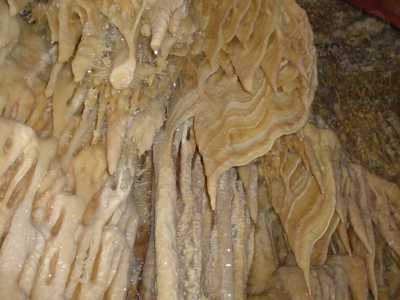 Il ventre della Terra d�altronde qui ha scatenato tutto il suo folle estro: dalle pareti ad esempio scendono "colate" calcitiche nei toni di un caldo dorato che a tratti prendono le sembianze di morbidi drappeggi
